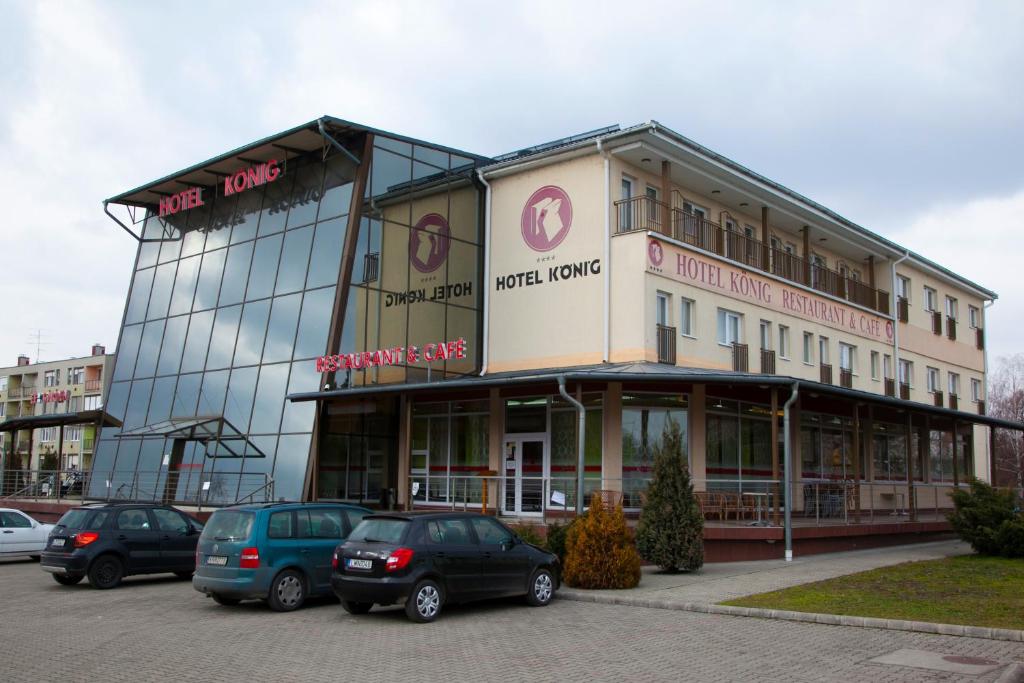 budynek z samochodami zaparkowanymi na parkingu w obiekcie König Hotel w mieście Nagykanizsa