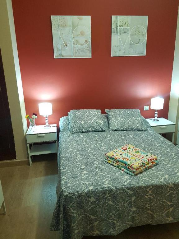 1 dormitorio con 1 cama con 2 mesas y 2 lámparas en TRIANA PUREZA 1, en Sevilla
