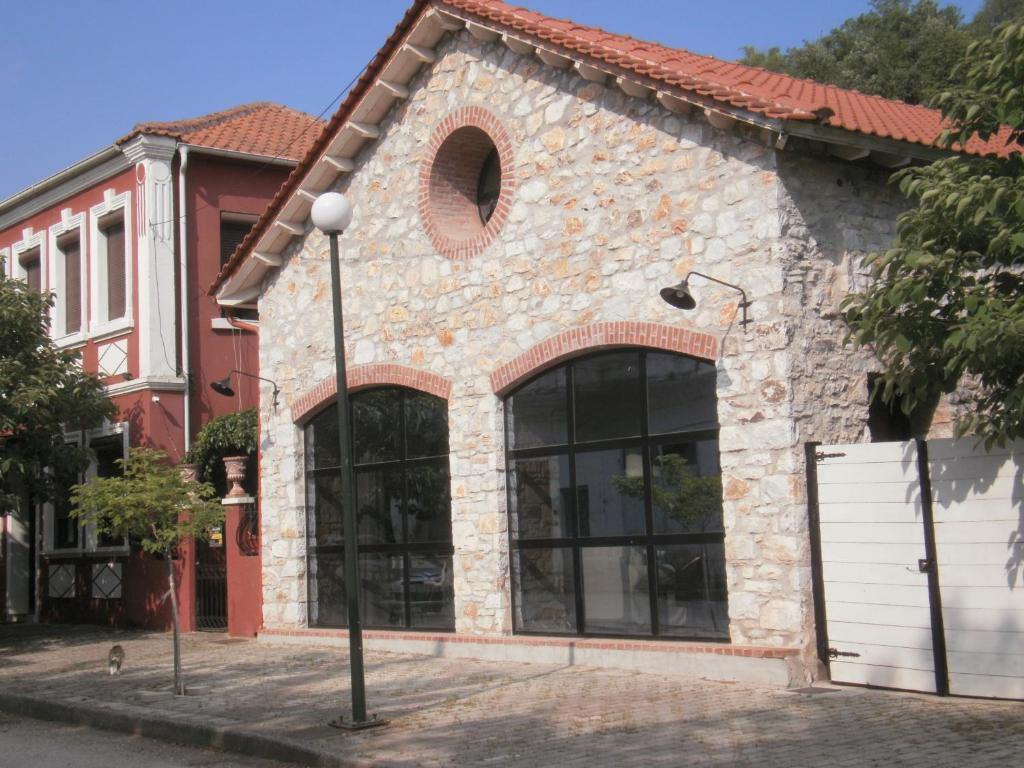 a brick building with large windows on a street at Joanna in Stavroupoli