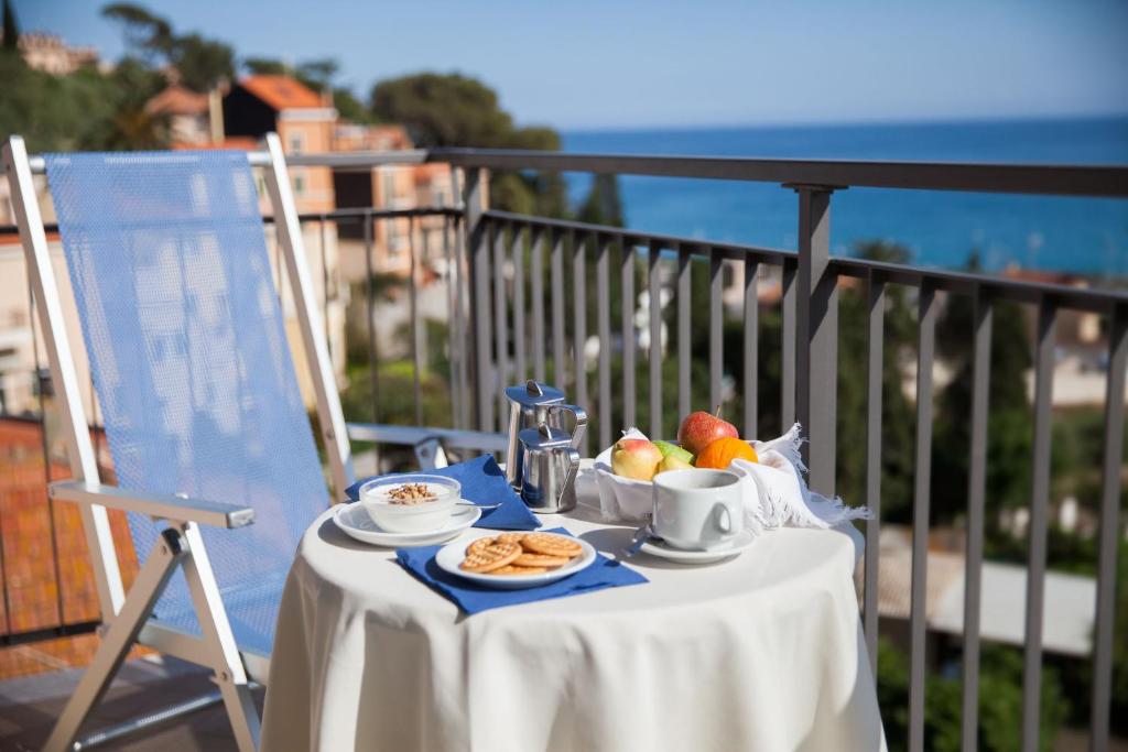 Hotel Europa في فينالي ليغوري: طاولة مع صحن من الفاكهة وكوب من القهوة