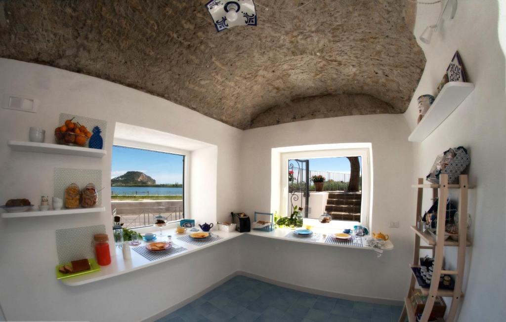 a room with two windows and a table with food at Domus Fortunae B&B in Bacoli