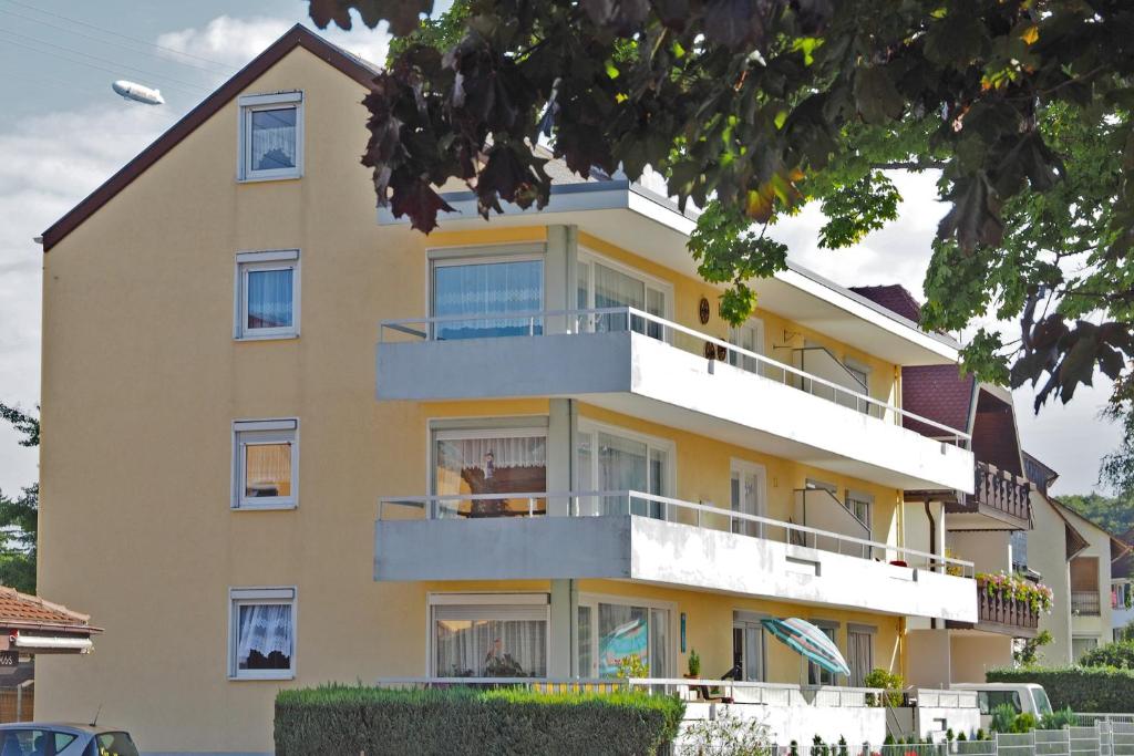 un grand bâtiment jaune avec balcon. dans l'établissement Gästehaus Moleblick, à Uhldingen-Mühlhofen