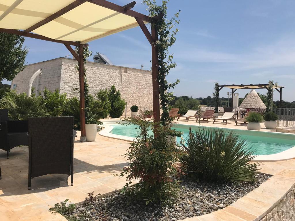 a patio with a swimming pool and a pavilion at Cappelluzzo in Cisternino