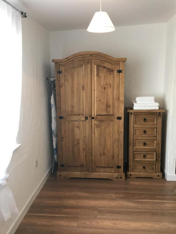 a room with a wooden cabinet and a dresser at The Potters Cottage in Clifden
