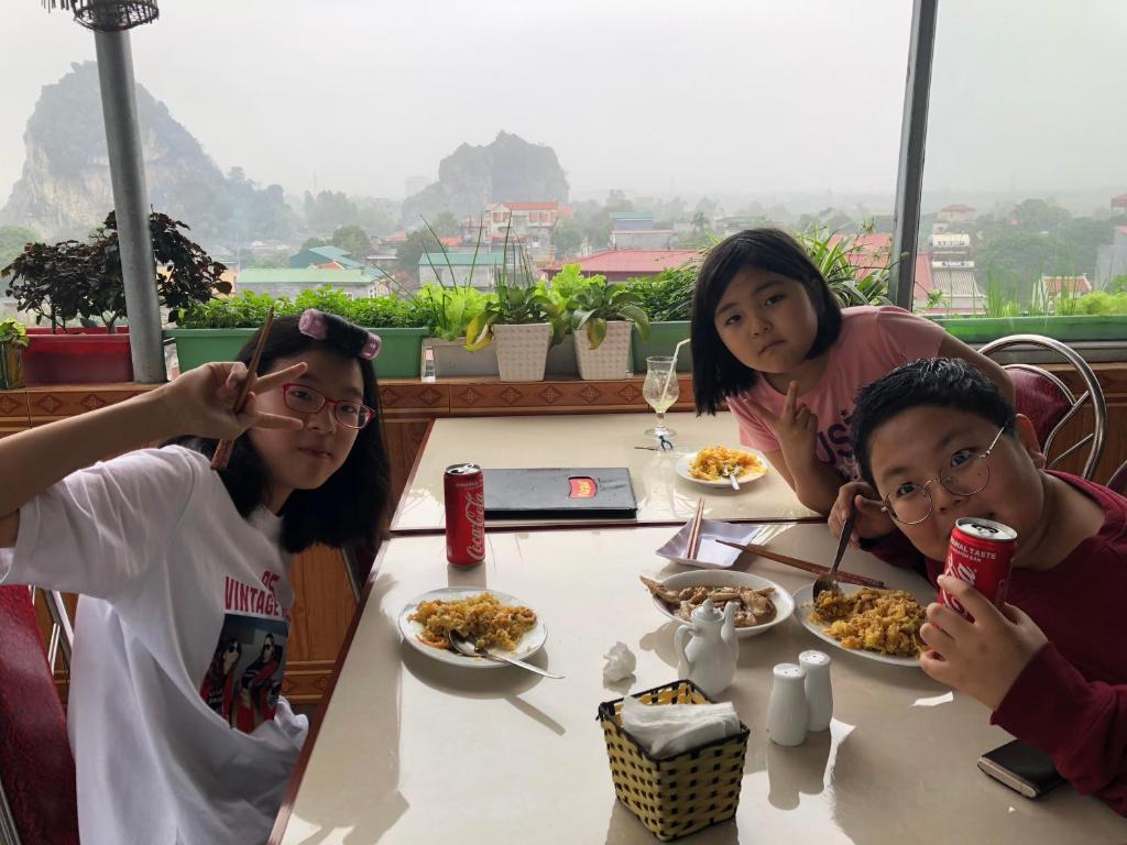three girls sitting at a table eating food at Sierra Homestay in Ninh Binh