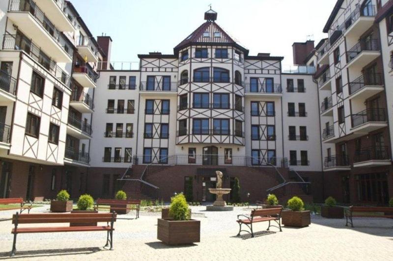 un grand bâtiment avec bancs devant lui dans l'établissement Luksusowe apartamenty Przy Plaży-Continental, à Krynica Morska