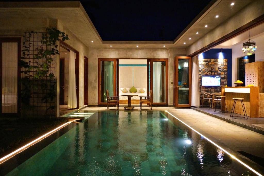 a swimming pool in a house with a living room at deLodtunduh Villa 2 in Ubud