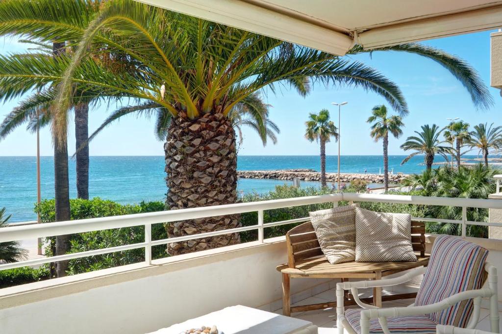 シッチェスにあるFront Beach Apartment by Hello Homes Sitgesのヤシの木と海の景色を望むバルコニー