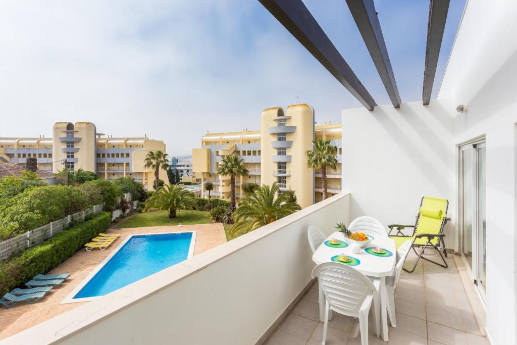 a balcony with a table and chairs and a swimming pool at Casa Harland by Seewest in Albardeira