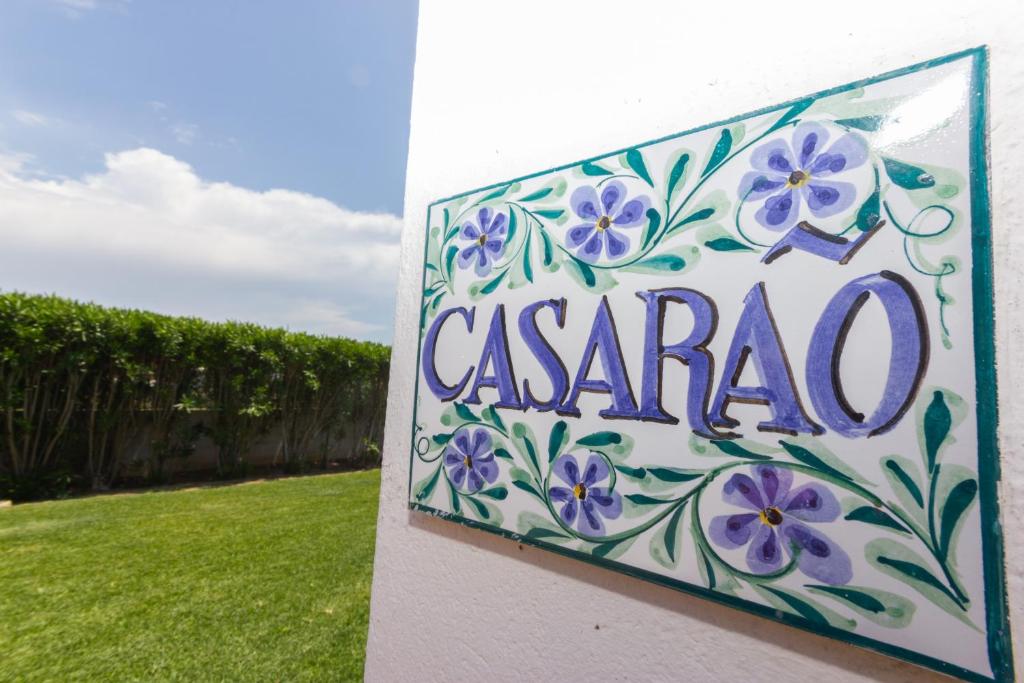 アルヴォルにあるCasinhoto - Casarao by Real Life Conciergeの紫の花が咲くヴィラの看板