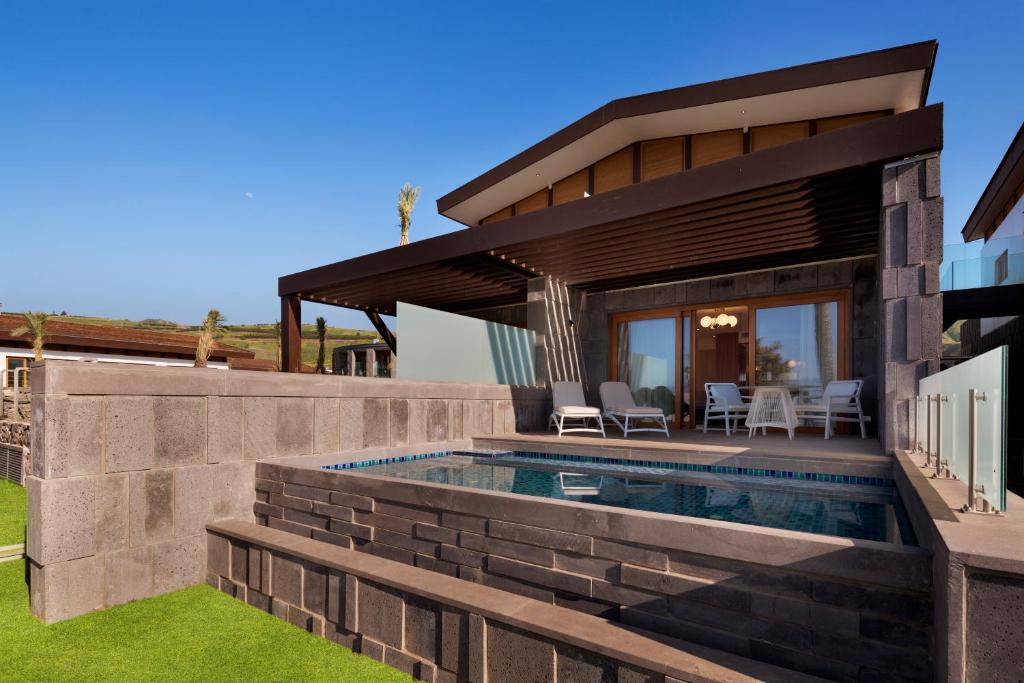 a villa with a swimming pool and a house at The Setai Sea Of Galilee in Ein Gev
