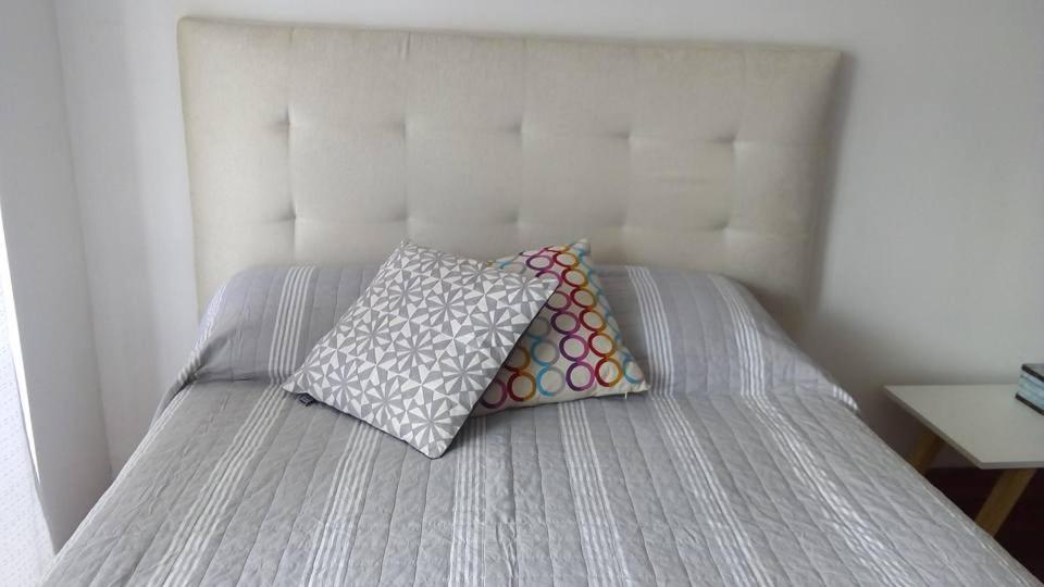 Una cama con dos almohadas encima. en M & C Suites en Buenos Aires
