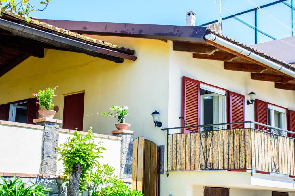 a house with red shutters and a balcony at Casa Il Negrito in Massa Lubrense