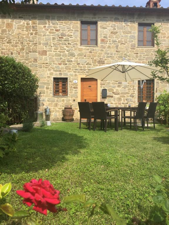a patio with a table and chairs and an umbrella at Antico borgo di Fabbrica in Pistoia