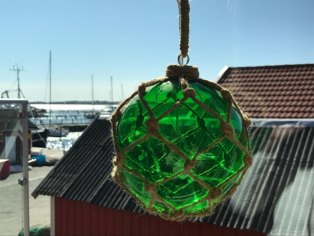 une boule de verre verte suspendue à un bâtiment dans l'établissement Björkö SeaLodge, à Björkö