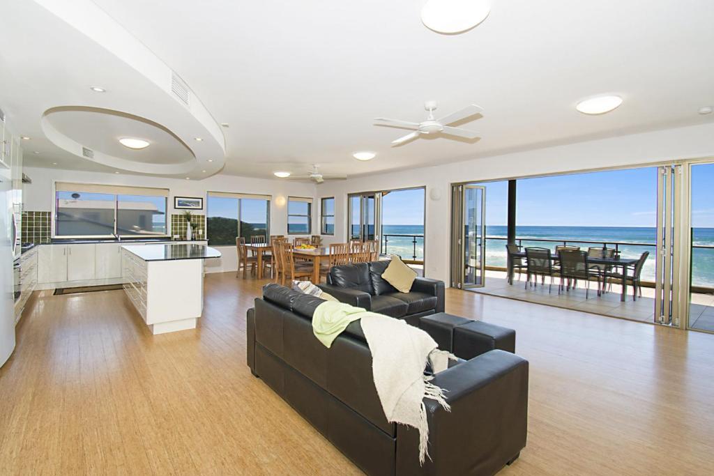 a living room with a couch and a kitchen and dining room at Lennox on the Beach Unit 2 - Lennox Head in Lennox Head