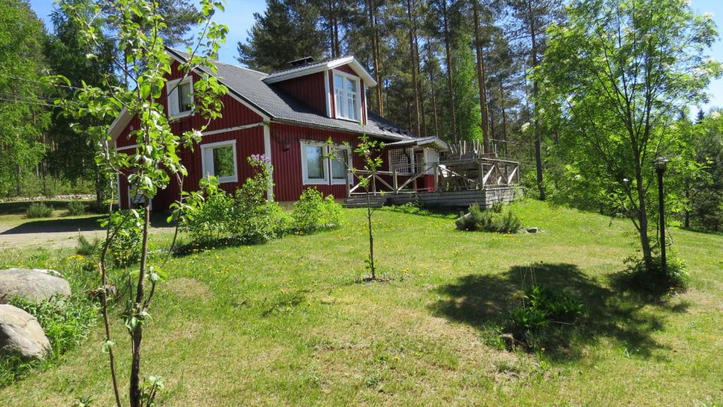 a red house in the middle of a yard at Mannimaatila Tera Lux in Punkaharju