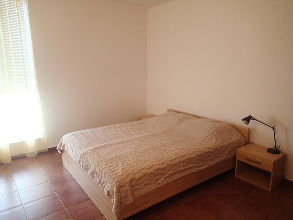クラネヴォにあるAtrium Apartmentのベッドルーム1室(ベッド1台、テーブルの上にランプ付)