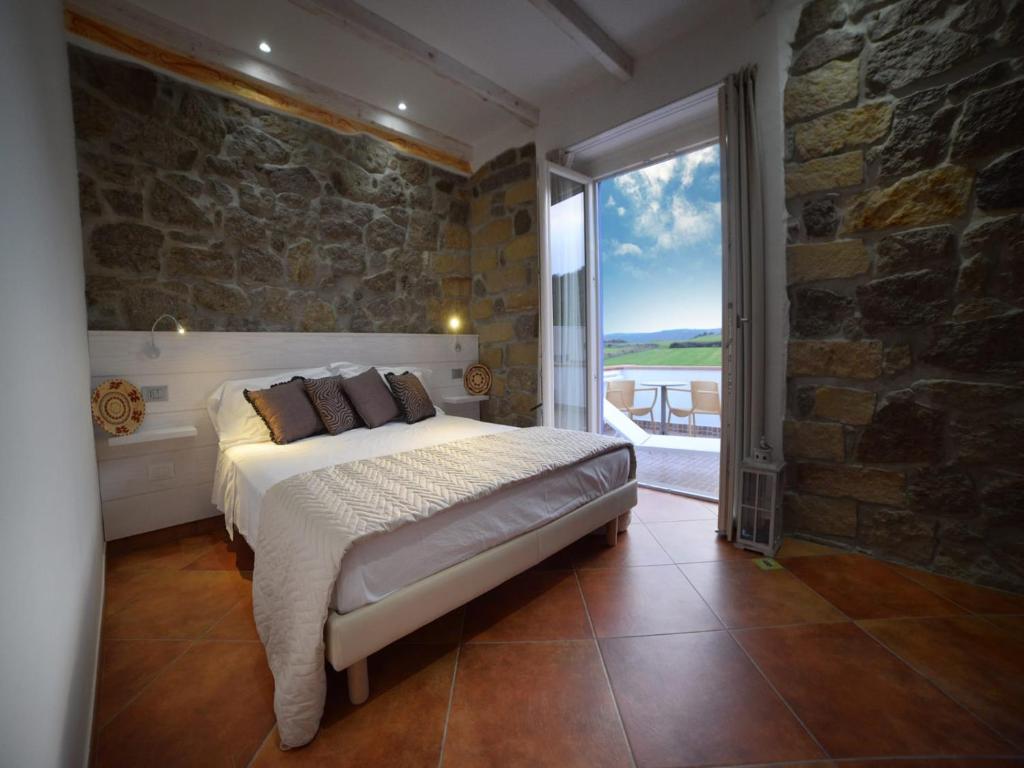 a bedroom with a bed and a large window at La Roccia Dell'Elefante in Castelsardo