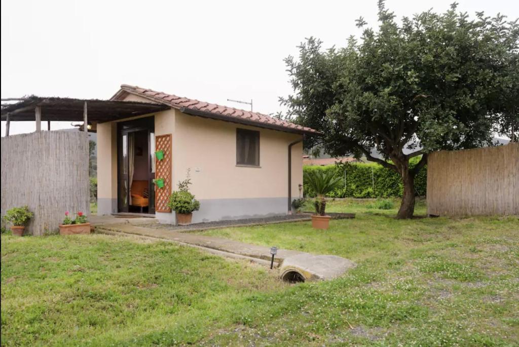 a small white house with a tree in a yard at Villetta Sotto Castagno in Castiglione della Pescaia