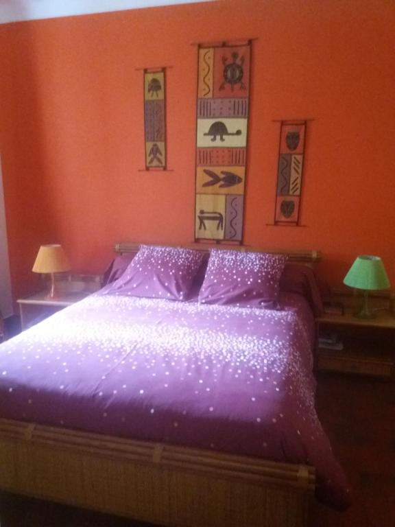 アジャクシオにあるVilla Savaneのベッドルーム(紫色のベッド、ランプ2つ付)