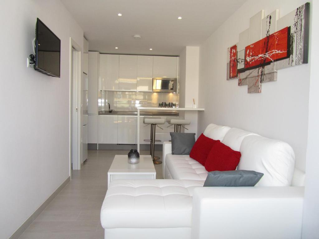 マルベーリャにあるApartamento Fontanillaのリビングルーム(白いソファ付)、キッチンが備わります。