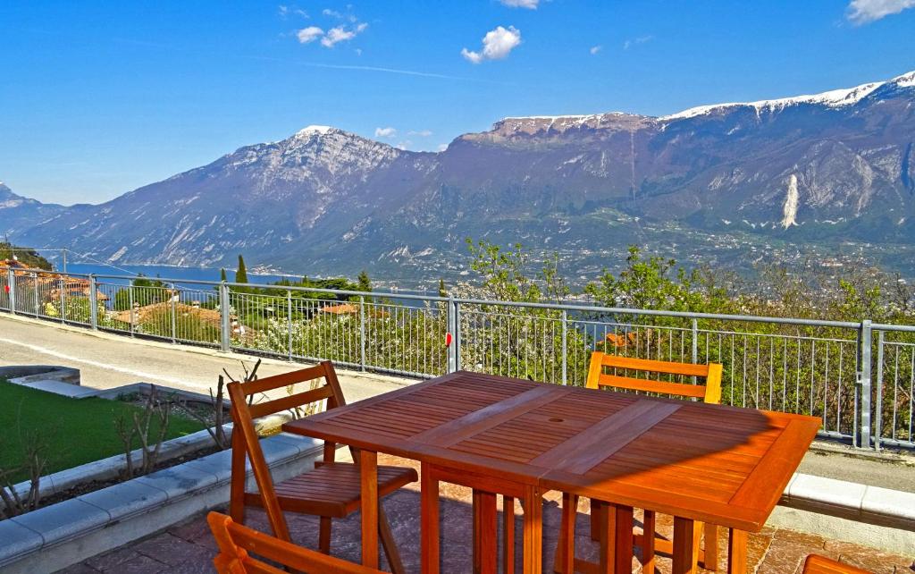 einen Holztisch und Stühle auf einem Balkon mit Bergblick in der Unterkunft La Quiete 23 Lake view apartment by Gardadomusmea in Tremosine sul Garda