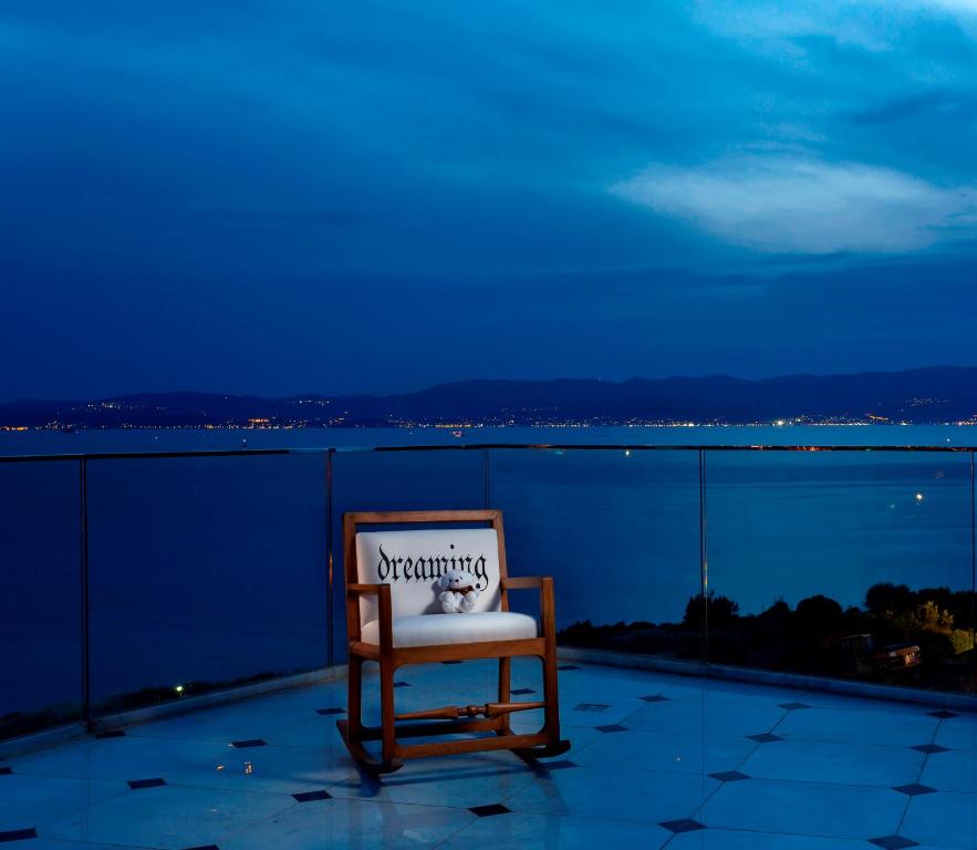 a chair with a sign on it sitting on a balcony at Sato Design Hotel in Çeşme