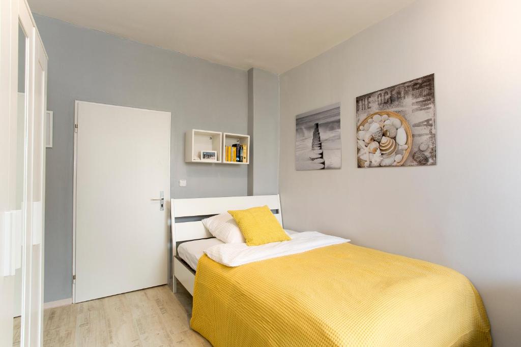 ニュルンベルクにあるFerienwohnung Raabstraßeのベッドルーム1室(黄色い毛布付きのベッド1台付)
