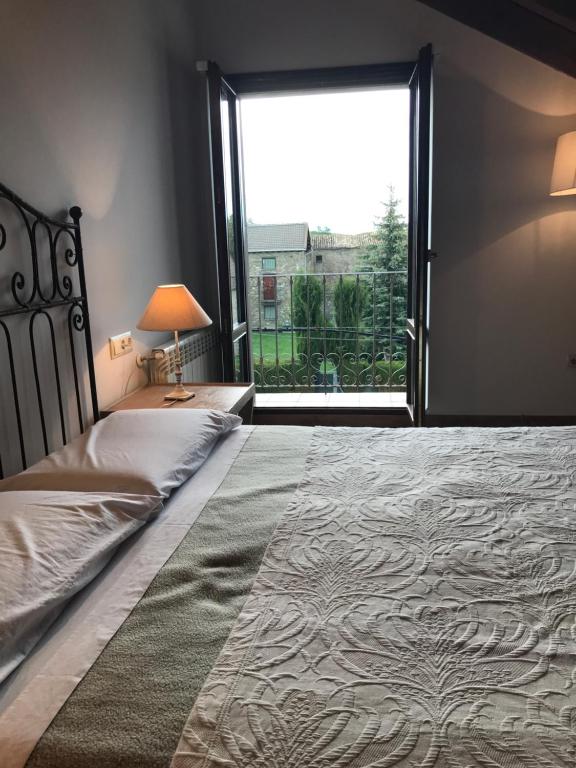 a bedroom with a large bed with a large window at Casa Campo in Abay