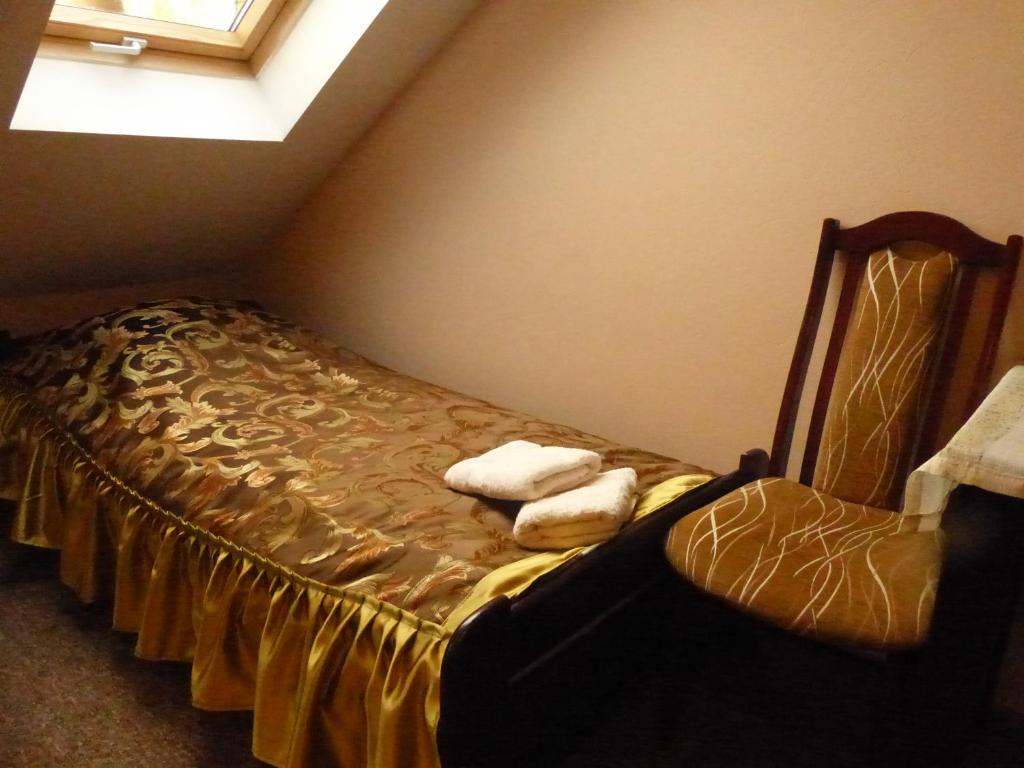 a bed in a corner with two towels on it at Karczma Góralska in Wisznice