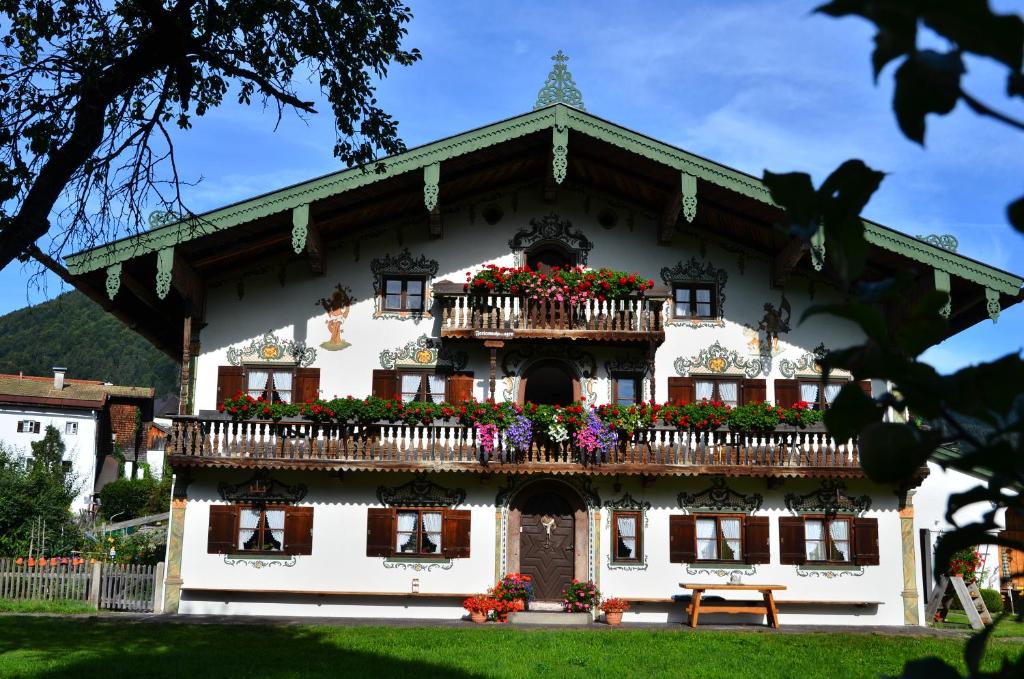 um edifício com uma varanda com flores em Schwabenbauernhof em Ruhpolding