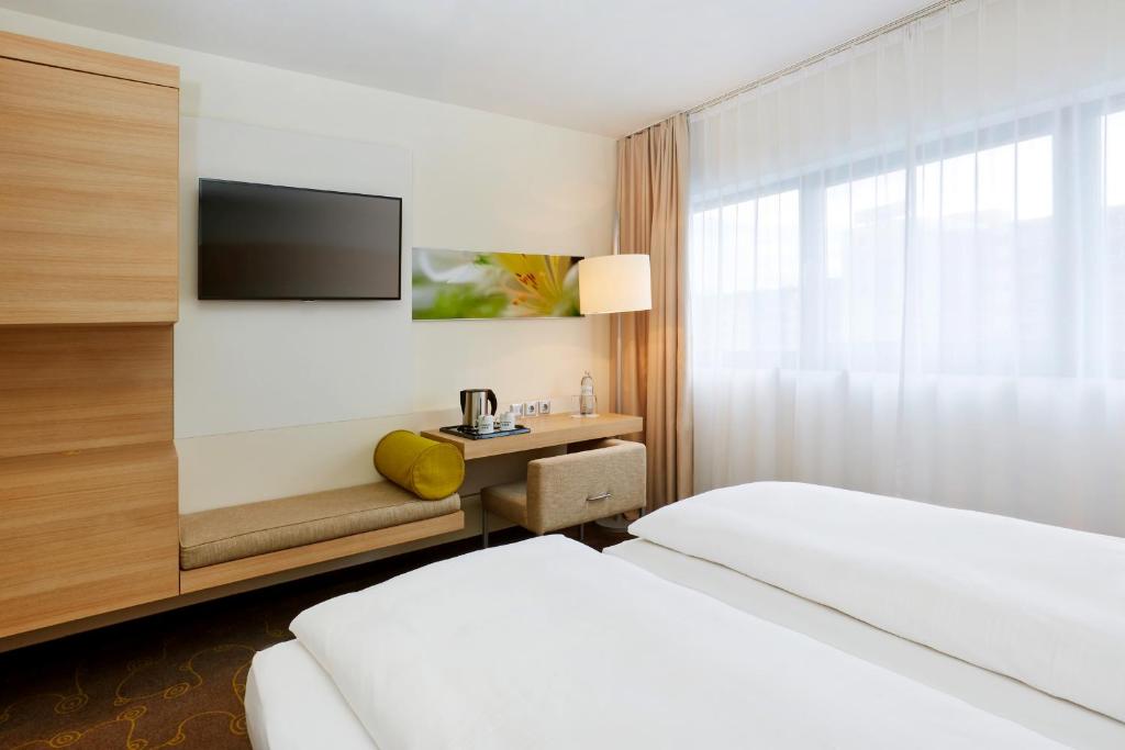 Postel nebo postele na pokoji v ubytování H+ Hotel Salzburg