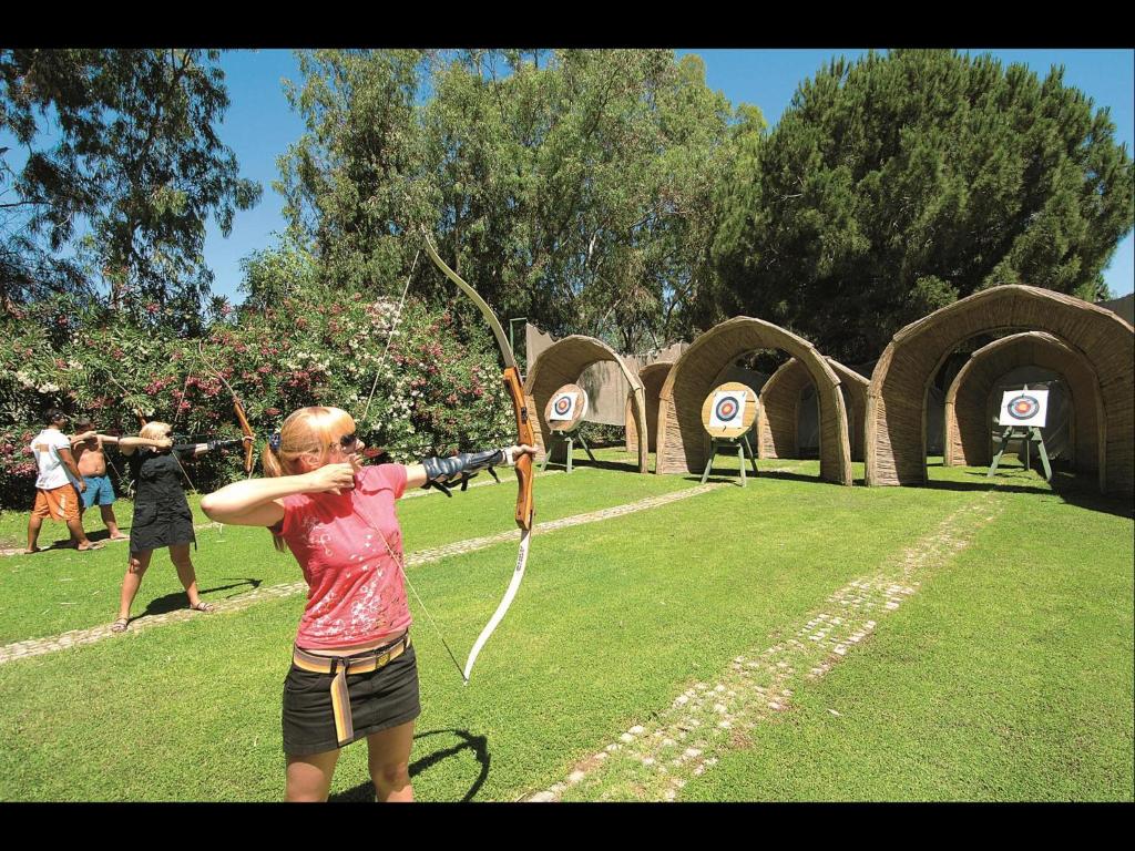 a woman holding a bow and arrows in a park at Megasaray Club Belek in Belek