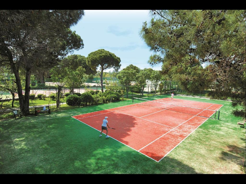 two people playing tennis on a tennis court at Megasaray Club Belek in Belek