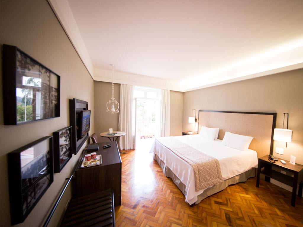 a hotel room with a bed and a flat screen tv at Hotel Escola Bela Vista in Volta Redonda