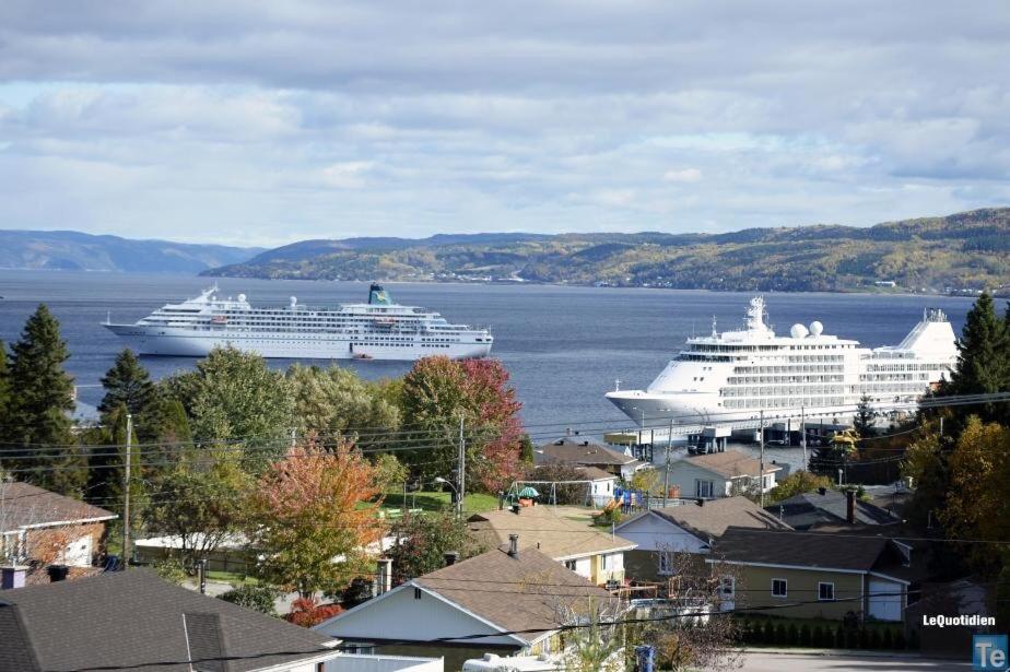 two cruise ships docked in a large body of water at Auberge Centre Ville in Saguenay