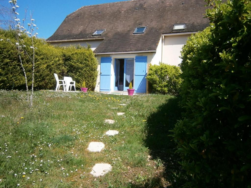 a house with a table and chairs in the yard at La Chenillette in Carsac-Aillac