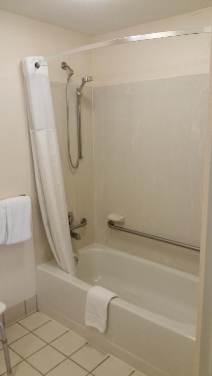 a bathroom with a tub and a shower with a shower curtain at Days Inn by Wyndham Chattanooga/Hamilton Place in Chattanooga