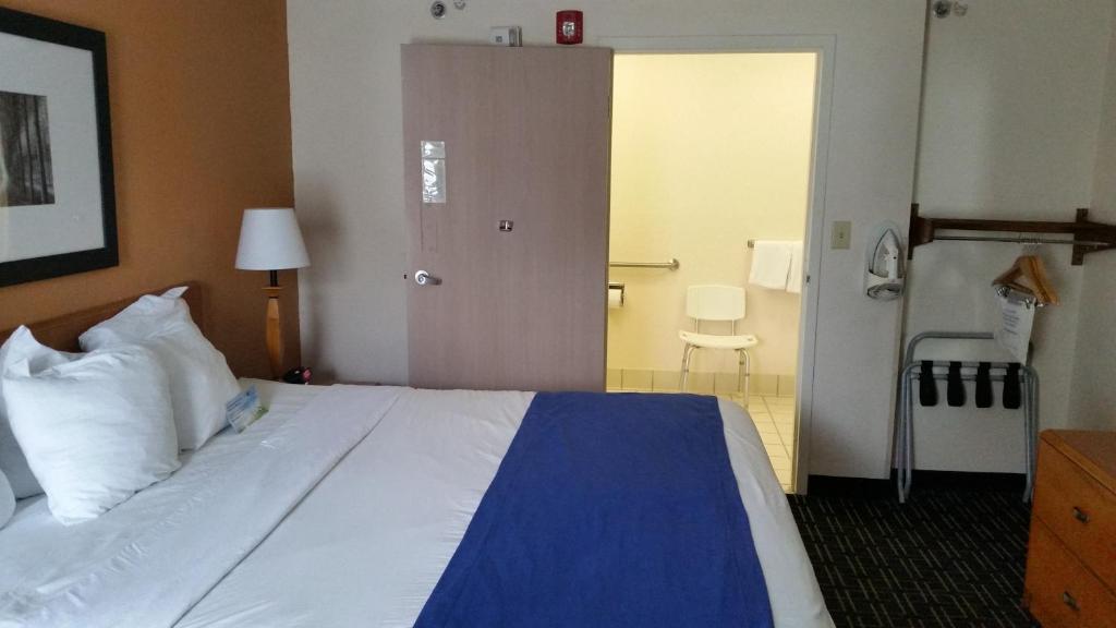 a hotel room with a large bed and a door at Days Inn by Wyndham Chattanooga/Hamilton Place in Chattanooga