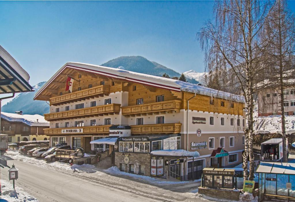 een groot gebouw in de sneeuw met een berg op de achtergrond bij Apparthotel Panorama in Flachau