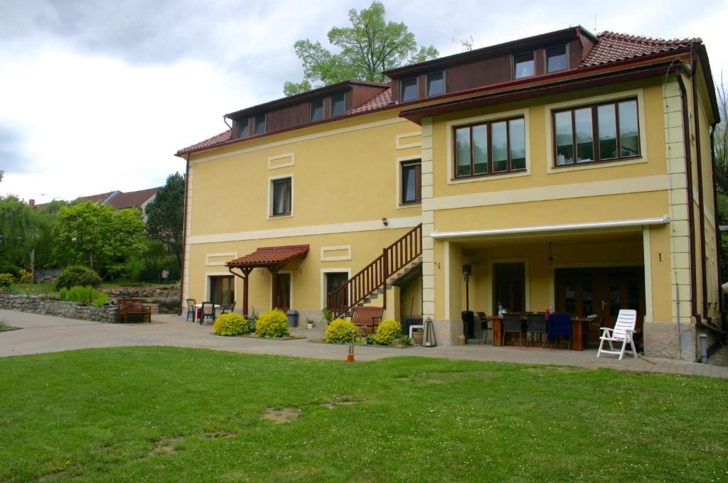 une maison jaune avec une pelouse devant elle dans l'établissement Penzion Art kutna Hora, à Kutná Hora