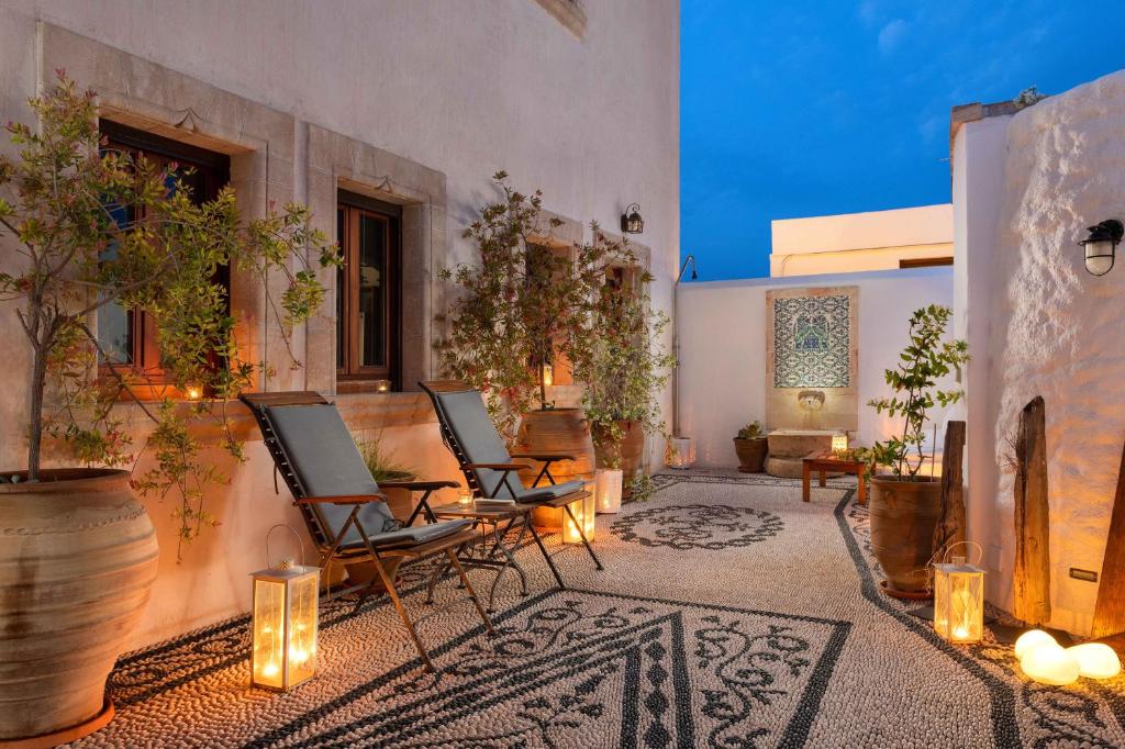 an outdoor patio with chairs and tables and lights at Villa Anastasia in Líndos