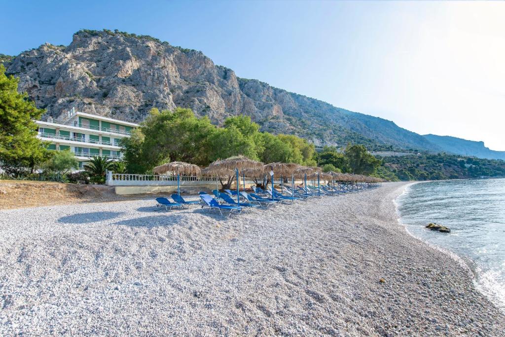 eine Gruppe von Stühlen und Sonnenschirmen am Strand in der Unterkunft Sun Hotel in Kineta