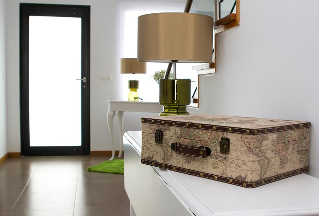 a suitcase sitting on a table with a lamp on it at Mountain and Sea in Ribeira Grande