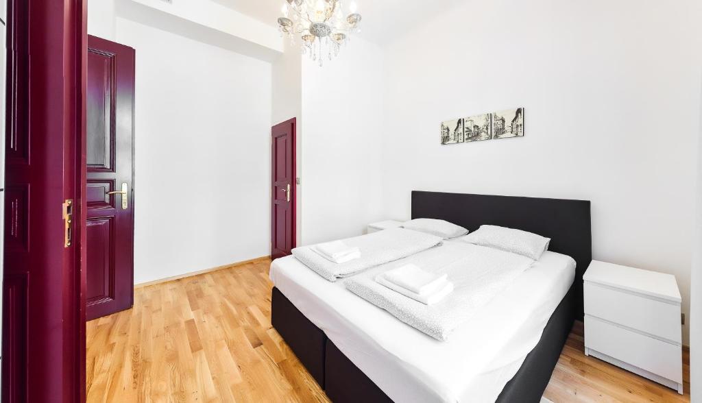 a bedroom with a bed with white sheets and white pillows at Apartments Zborovska in Prague