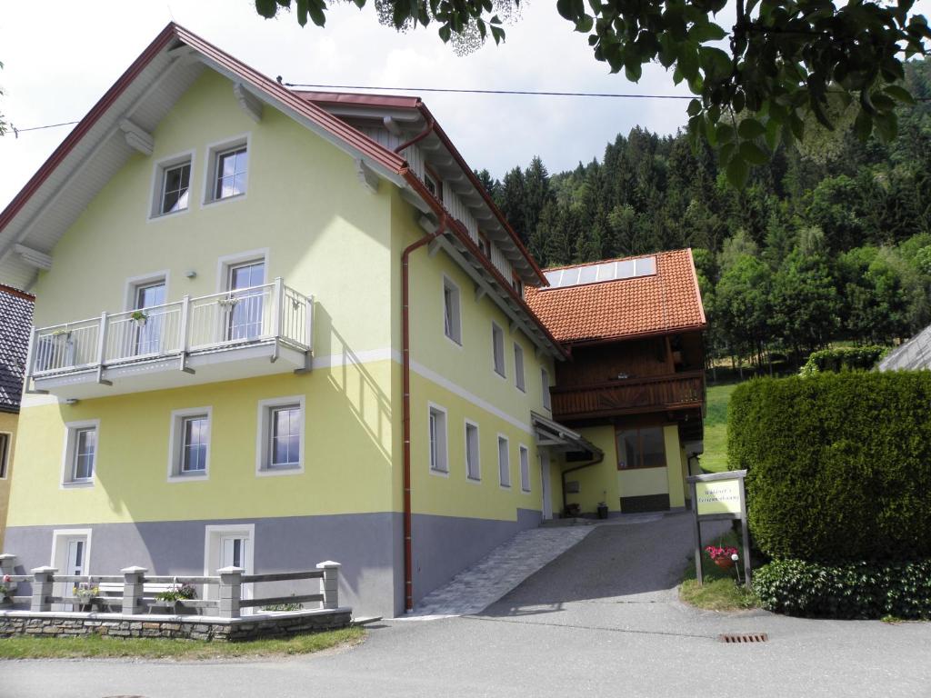 una casa amarilla con techo marrón en Waldner's Ferienwohnung, en Hermagor