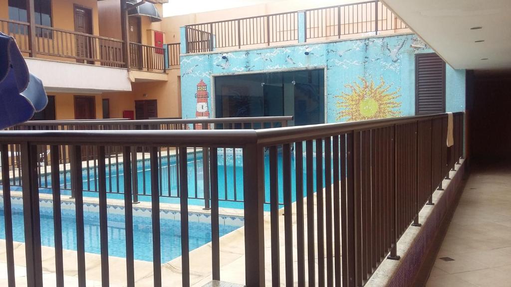 una piscina con una valla junto a un edificio en Clube Praiano, en Cabo Frío