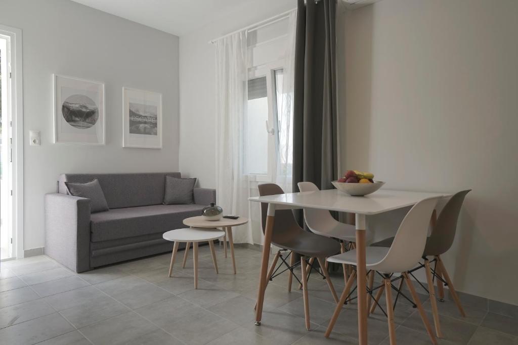 ケラモティにあるIfigenia Apartmentsのリビングルーム(テーブル、椅子、ソファ付)