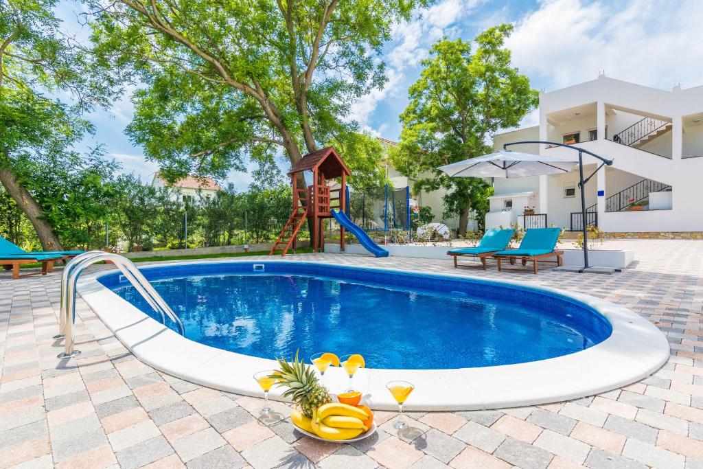 een afbeelding van een zwembad in een huis met speeltuin bij Apartments Marina in Bibinje